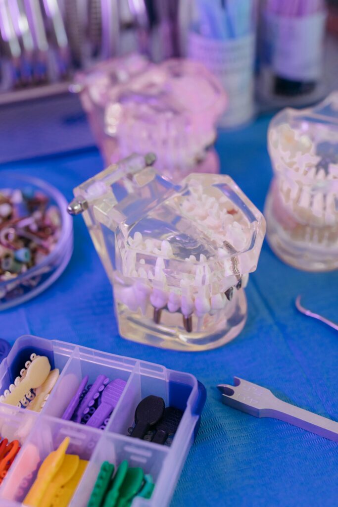Close-up of dental models and tools on a blue sterile table, showcasing orthodontic equipment.