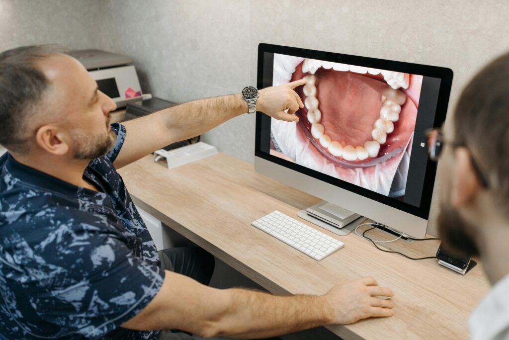 pexels-photo-6812508-6812508 Dentist explains dental condition using intraoral images on a computer screen.